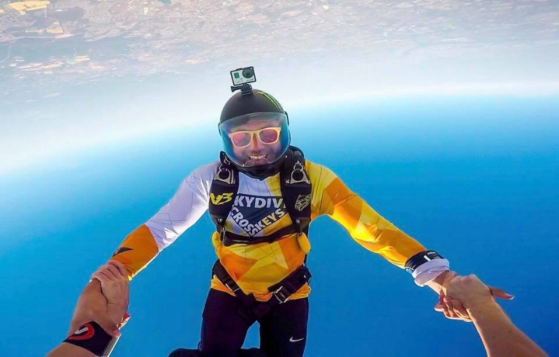 Videographer taking video of a skydiver with a helmet cam after a jump