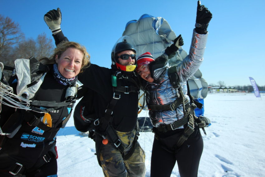 Skydivers in the winter celebrating after the jump.