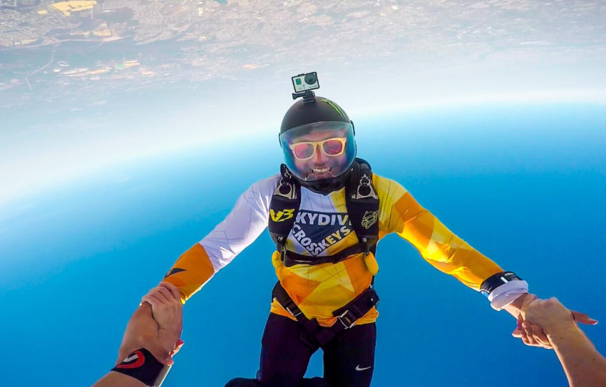 Skydiver floats upside down in the air.