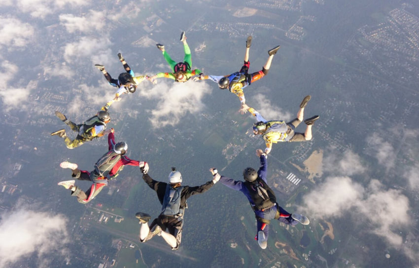 A group of skydivers make a ring in the air.